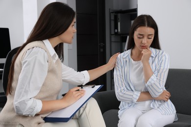 Photo of Professional psychologist working with young woman in office
