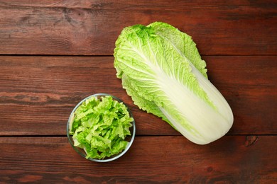 Whole and cut fresh Chinese cabbage on wooden table, top view