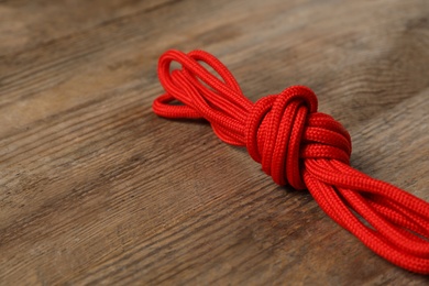 Photo of Red shoelaces on wooden background. Stylish accessory