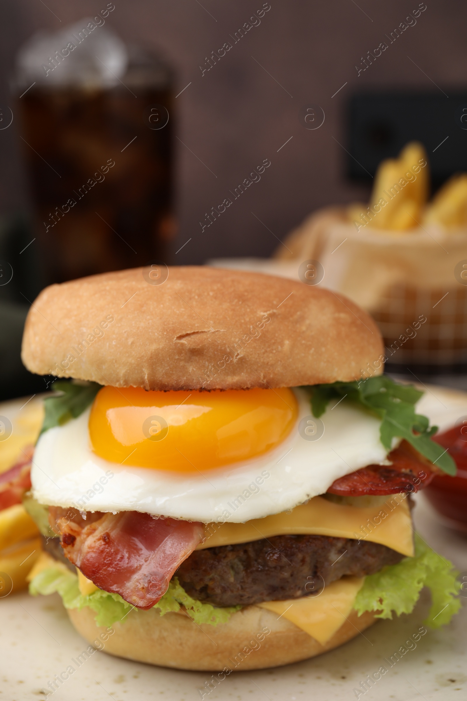 Photo of Delicious burger with fried egg on table, closeup