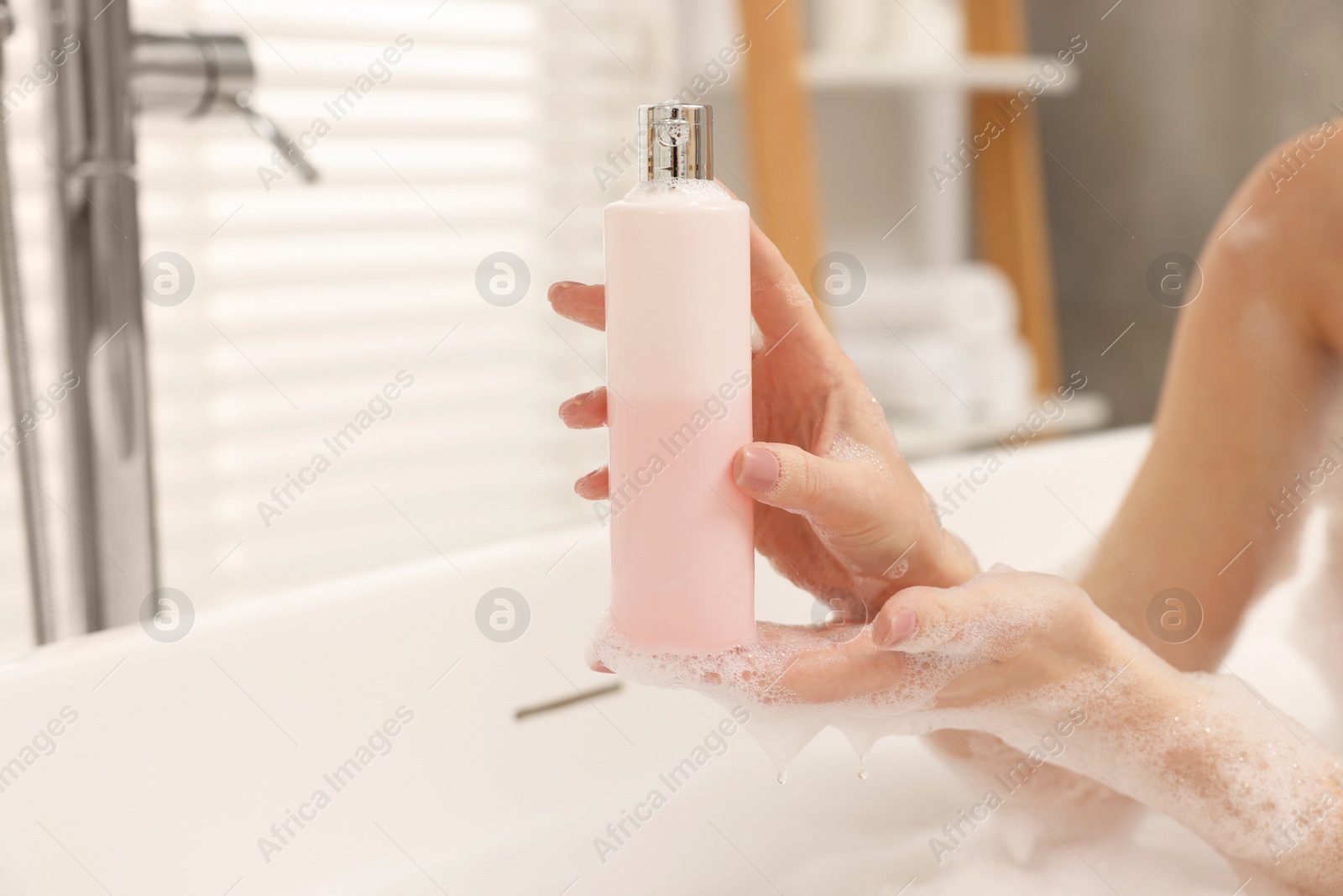 Photo of Woman taking bath with shower gel in bathroom, closeup. Space for text