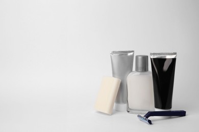 Different men's shaving accessories on light background, space for text