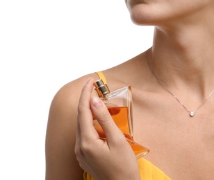 Young woman spraying perfume onto skin against white background, closeup