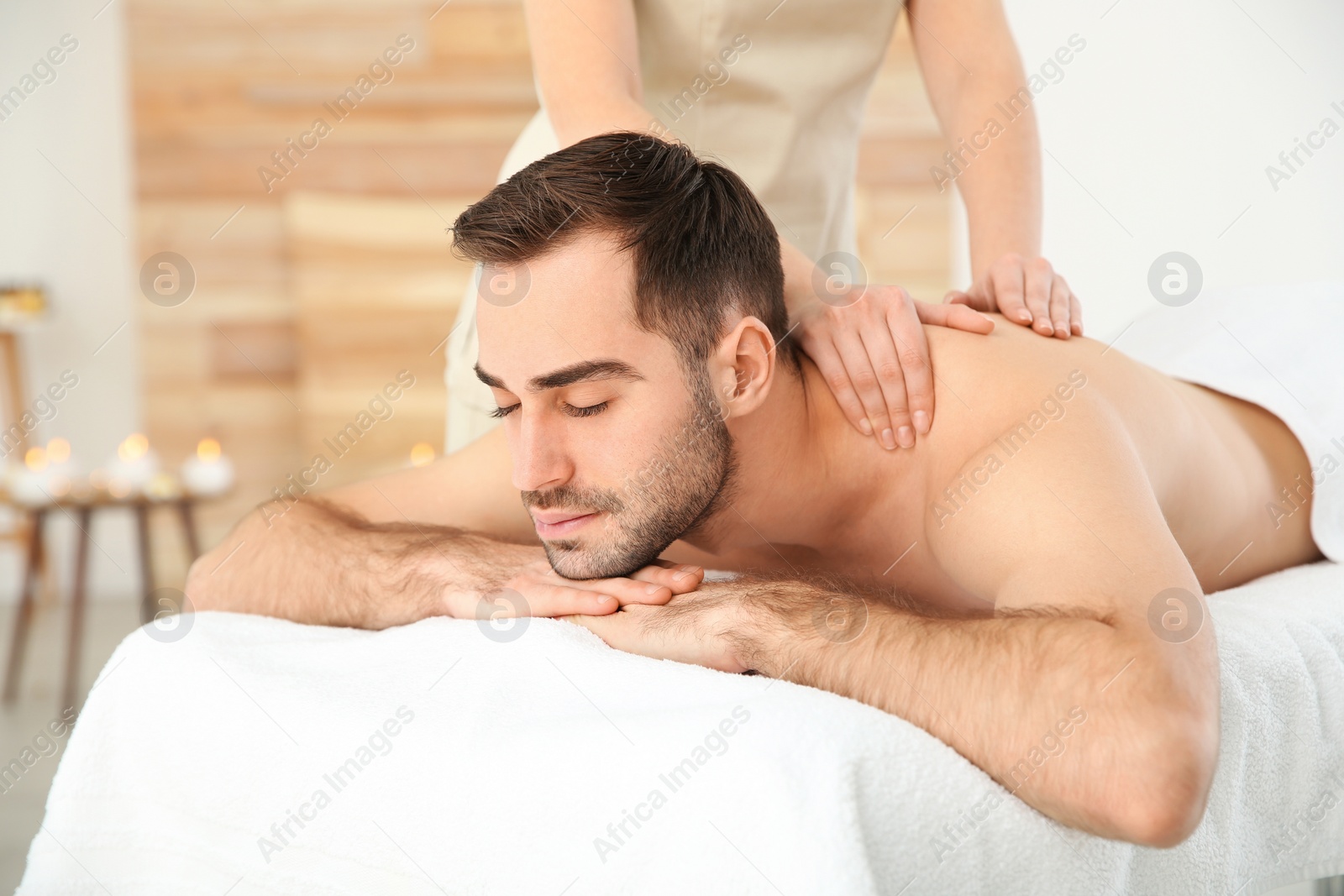 Photo of Handsome man receiving back massage in spa salon