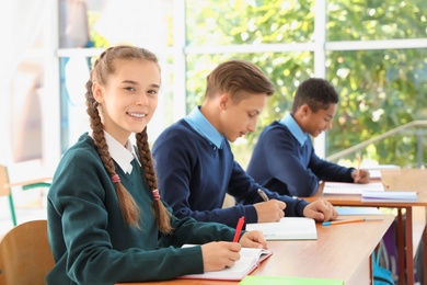 Photo of Teenage students in classroom. Stylish school uniform