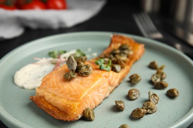 Photo of Delicious salmon with capers and sauce on plate, closeup