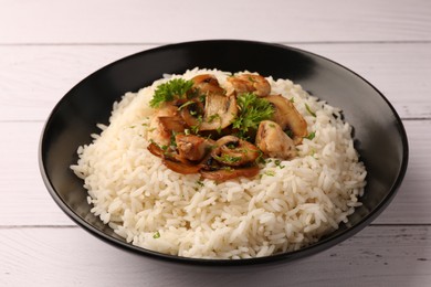 Photo of Delicious rice with parsley and mushrooms on white wooden table, closeup