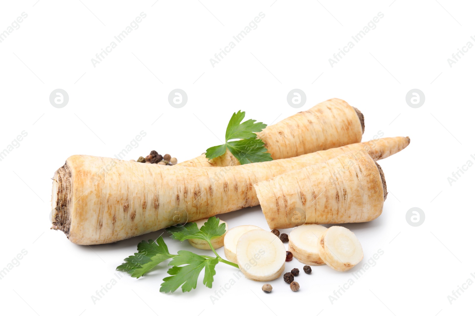 Photo of Whole and cut raw parsley roots, fresh herb isolated on white