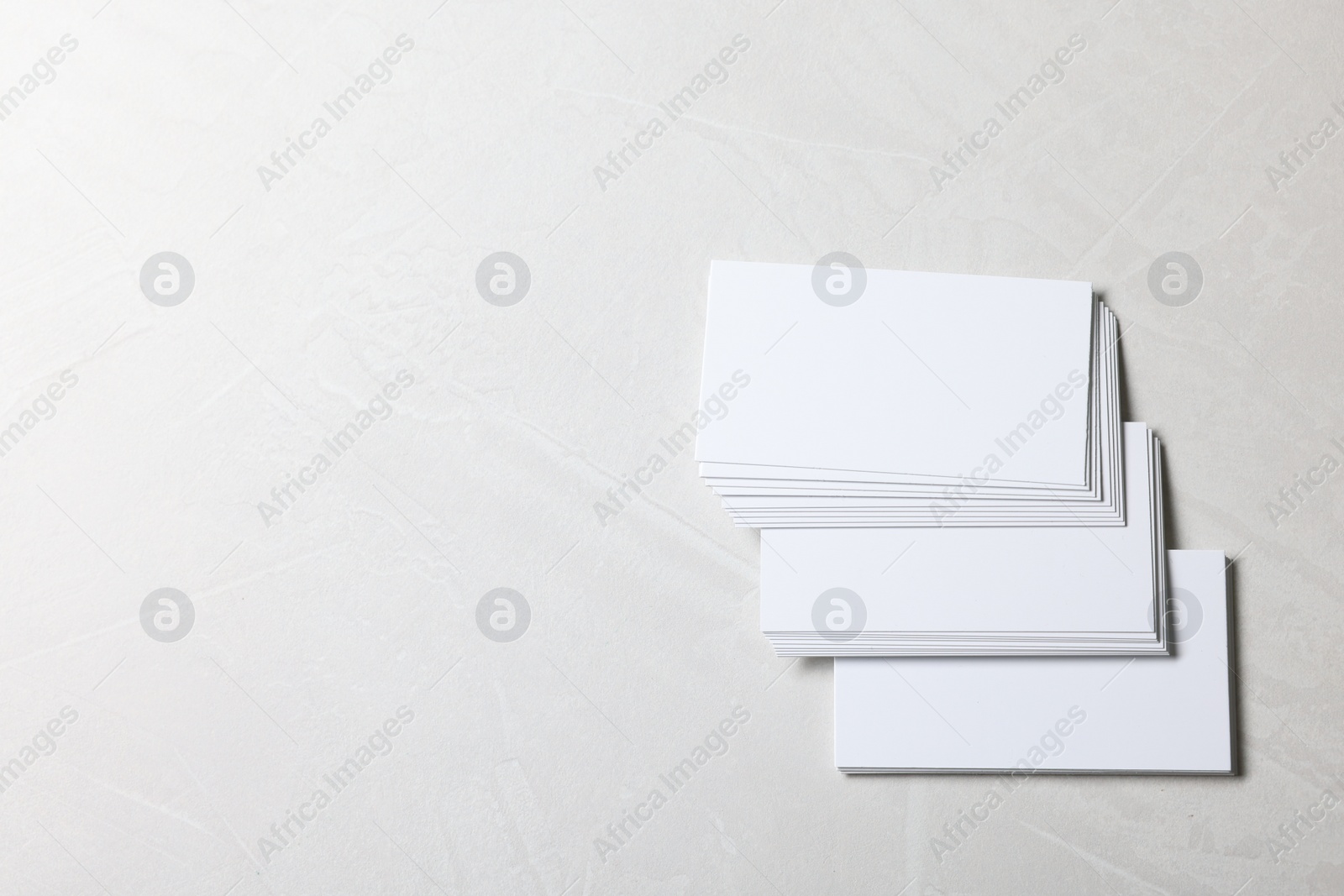 Photo of Blank business cards on light grey textured background, top view. Mockup for design