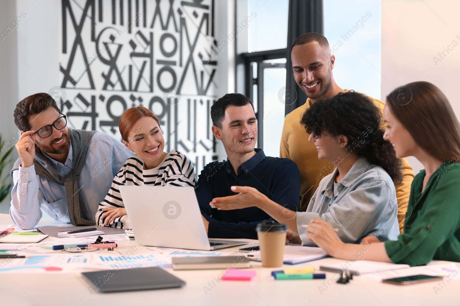 Photo of Team of employees working together at table in office. Startup project