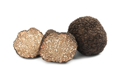 Photo of Cut and whole black truffles isolated on white