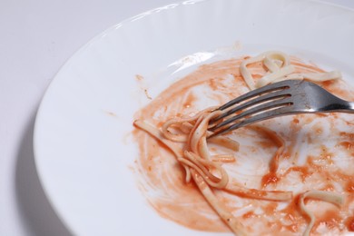 Photo of Dirty plate and fork on white background, closeup