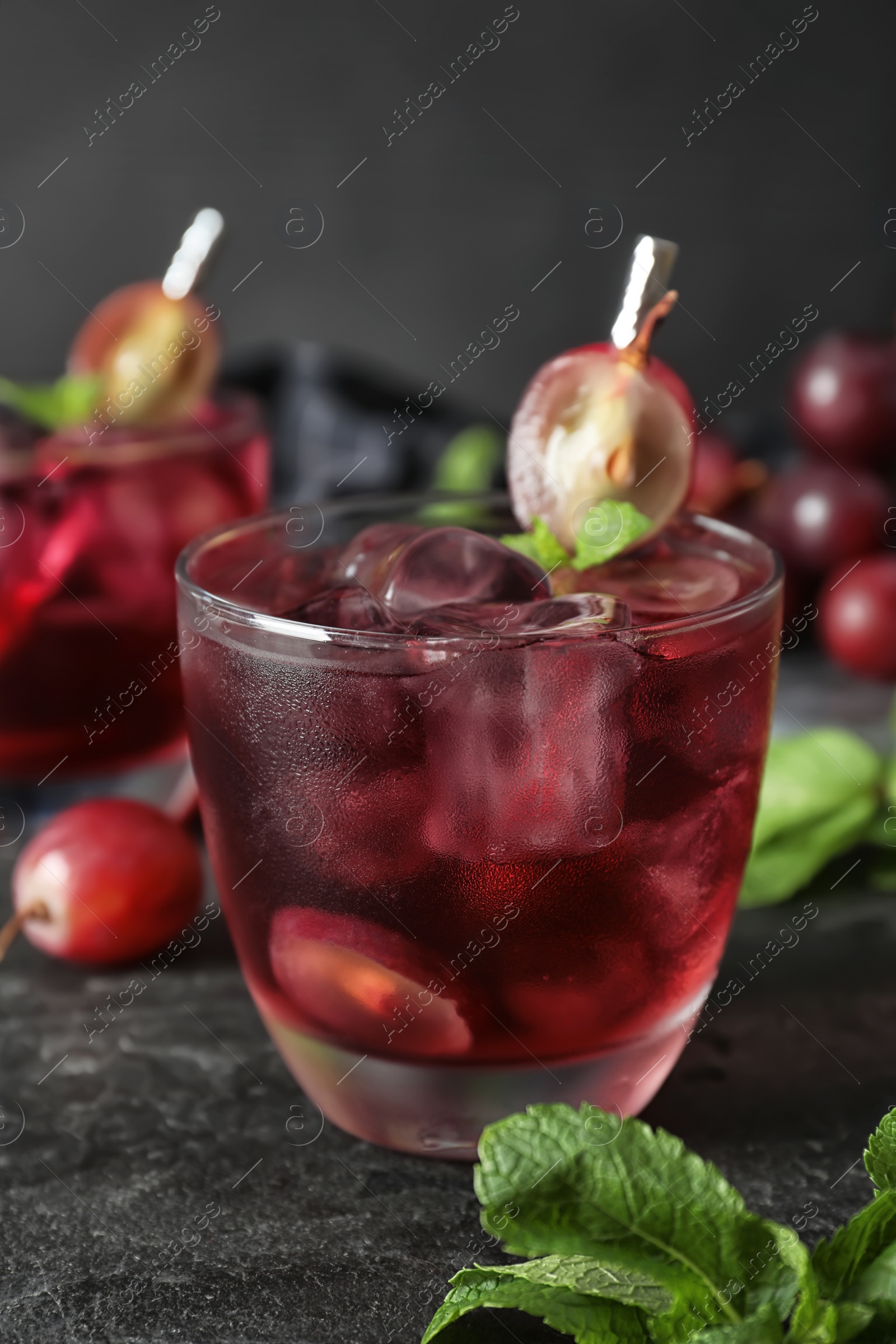 Photo of Delicious grape soda water on black table. Refreshing drink