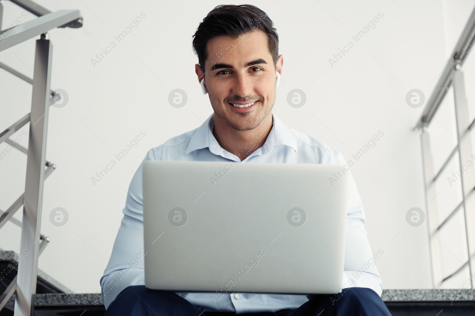 Photo of Portrait of young man with laptop indoors