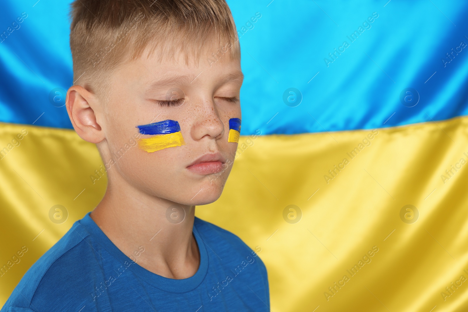 Photo of Little boy near Ukrainian flag. No war concept