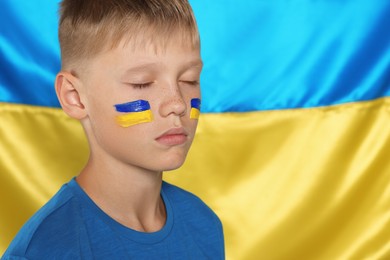 Little boy near Ukrainian flag. No war concept