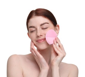 Washing face. Young woman with cleansing brush on white background