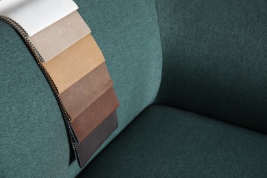 Photo of Catalog of colorful fabric samples on green sofa. Space for text