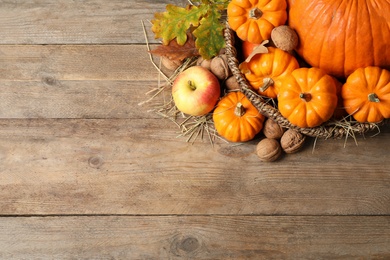Photo of Flat lay composition with ripe pumpkins and autumn leaves on wooden table, space for text. Happy Thanksgiving day