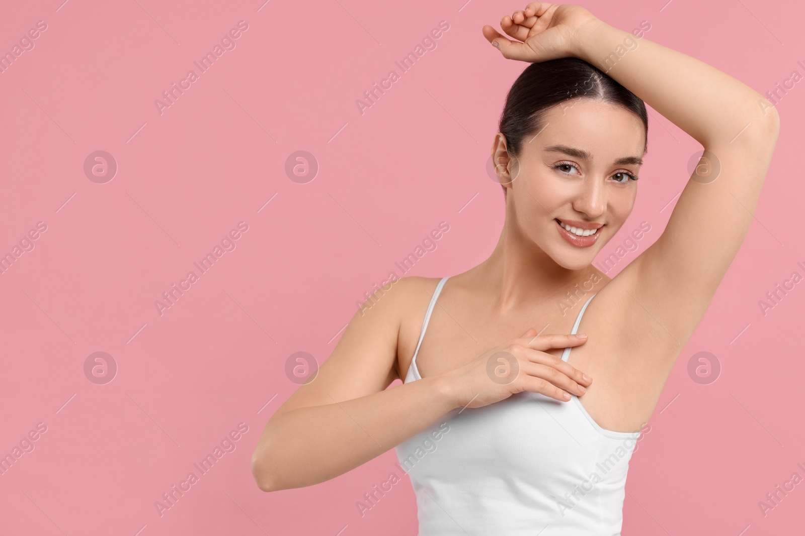 Photo of Beautiful woman showing armpit with smooth clean skin on pink background, space for text