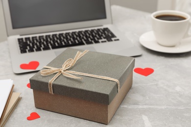 Gift box and red hearts on light grey marble table. Valentine's day celebration