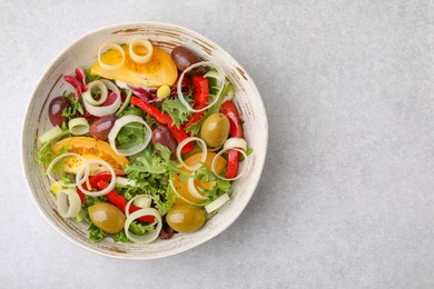 Bowl of tasty salad with leek and olives on light table, top view. Space for text