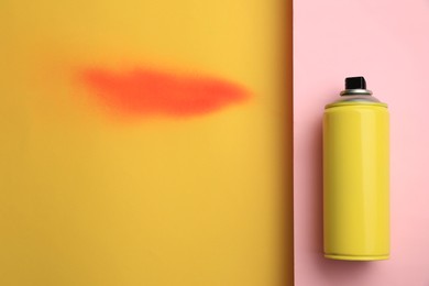 Photo of Can of graffiti paint and sprayed dye sample on color background, top view