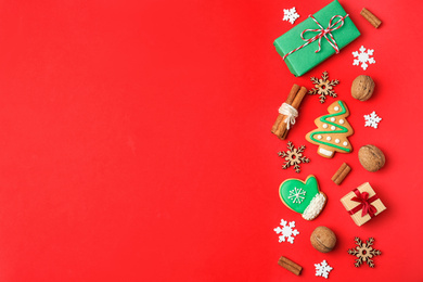 Flat lay composition with Christmas decorations and treats on red background, space for text. Winter holidays