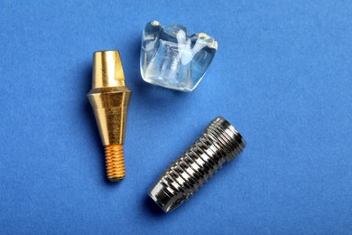 Parts of dental implant on blue background, flat lay