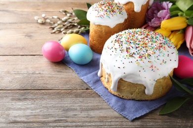 Photo of Beautiful Easter cake and painted eggs on wooden table