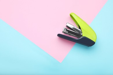 Photo of New bright stapler on color background, top view. Space for text