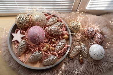 Photo of Beautiful Christmas tree baubles and fairy lights on window sill indoors, above view