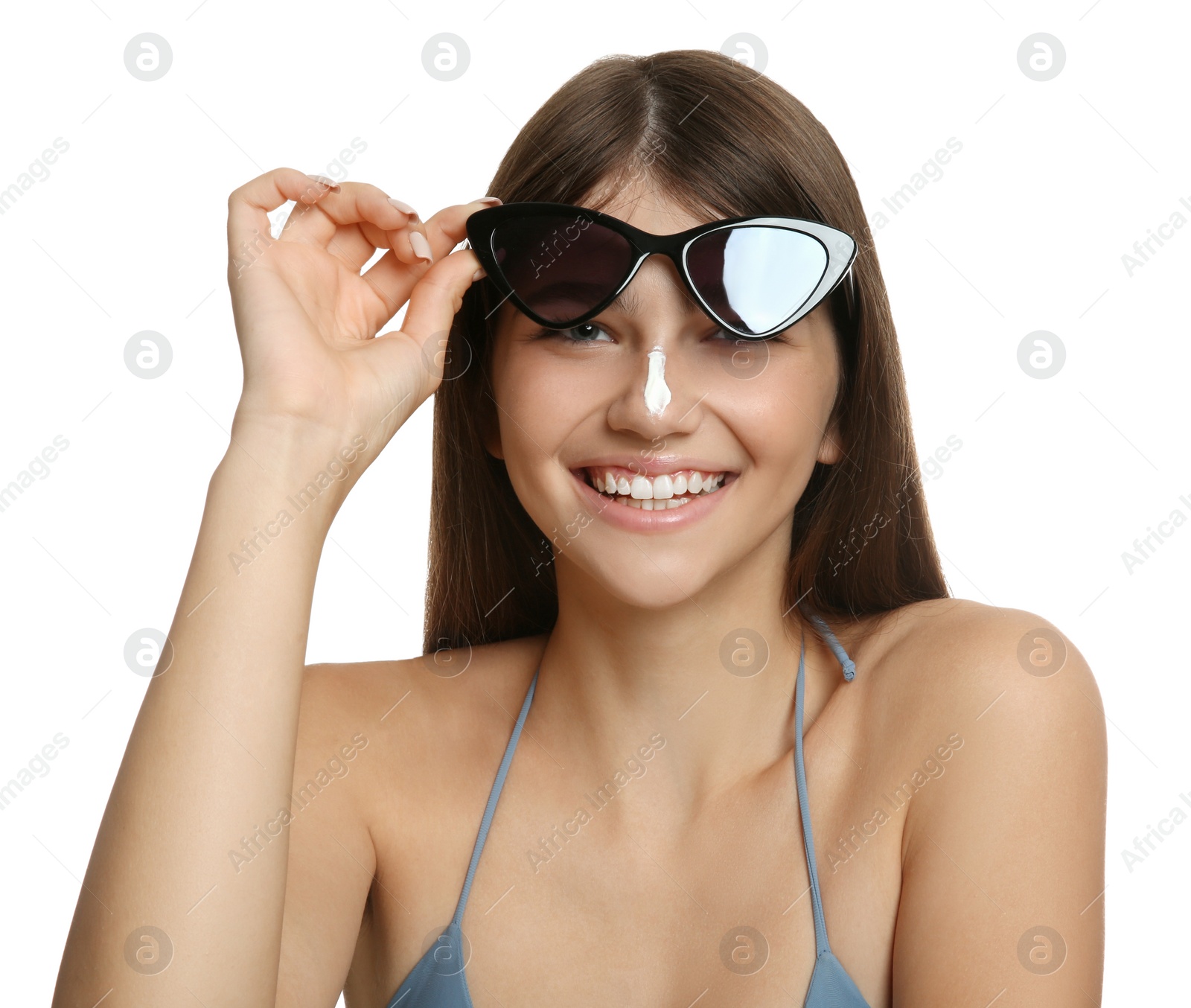 Photo of Teenage girl with sun protection cream on her nose against white background