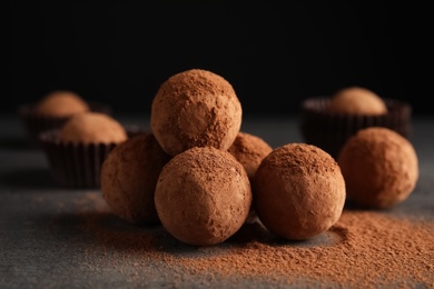 Photo of Tasty chocolate truffles powdered with cocoa on table