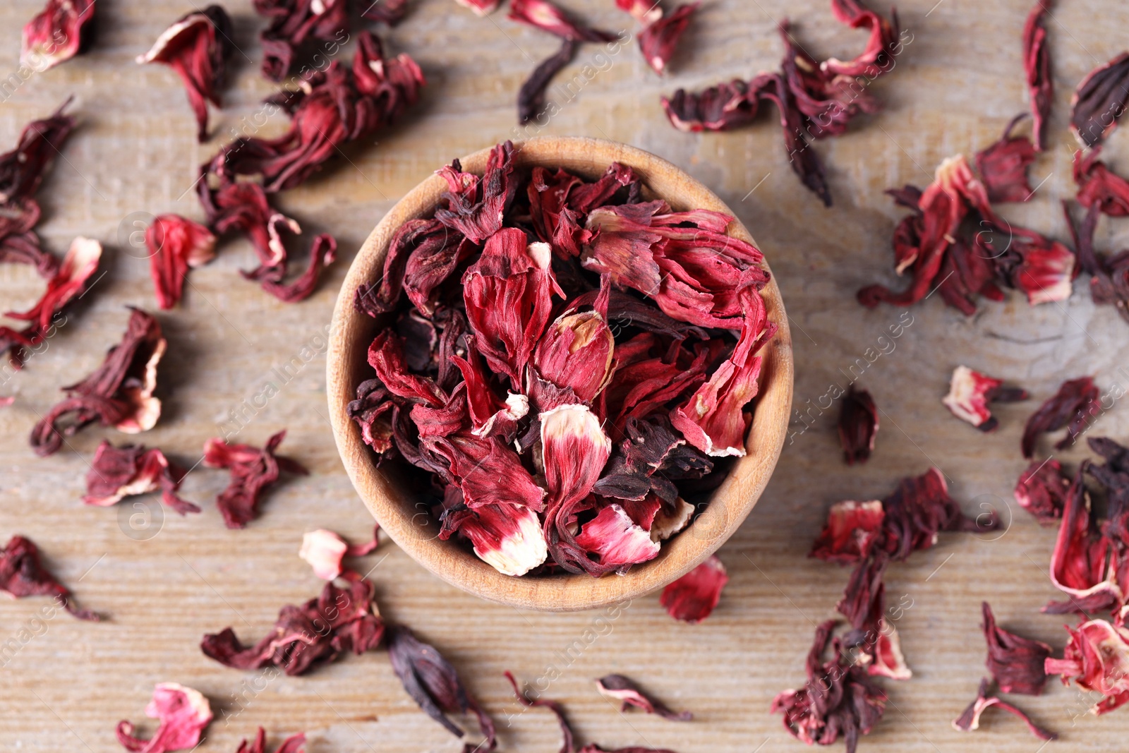 Photo of Dry hibiscus tea on wooden table, flat lay