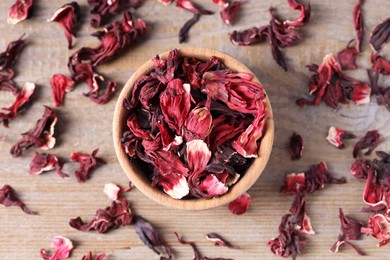 Photo of Dry hibiscus tea on wooden table, flat lay