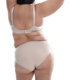Back view of overweight woman in beige underwear on white background, closeup. Plus-size model