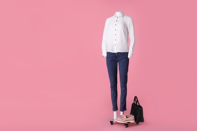 Photo of Female mannequin with shoes and bag dressed in white shirt and jeans on pink background, space for text. Stylish outfit