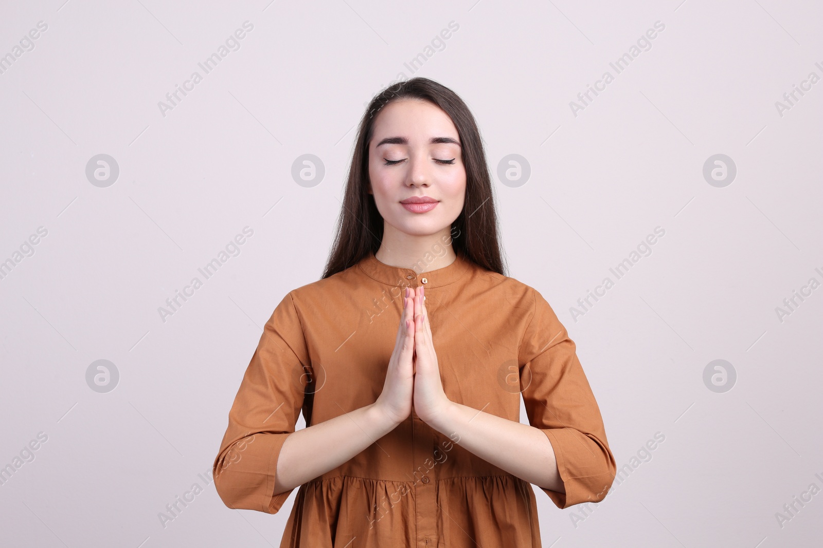 Photo of Young woman meditating on beige background. Stress relief exercise