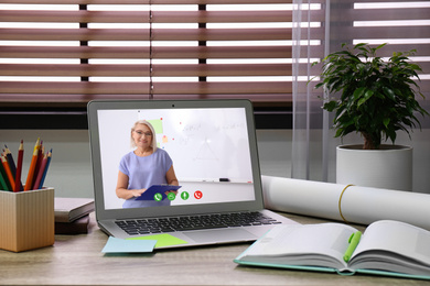Image of Modern laptop on wooden desk indoors. Online learning