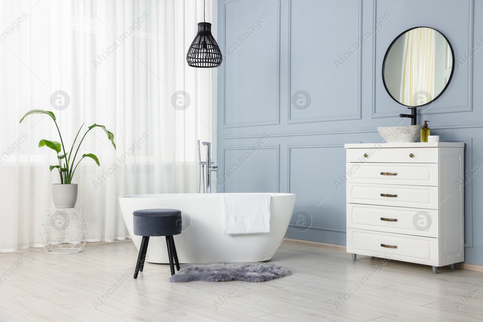 Photo of Stylish bathroom interior with beautiful tub, stool and houseplant