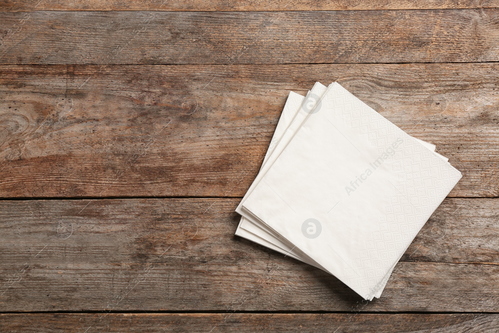 Photo of Clean napkins on wooden background, top view with space for text