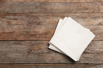 Photo of Clean napkins on wooden background, top view with space for text