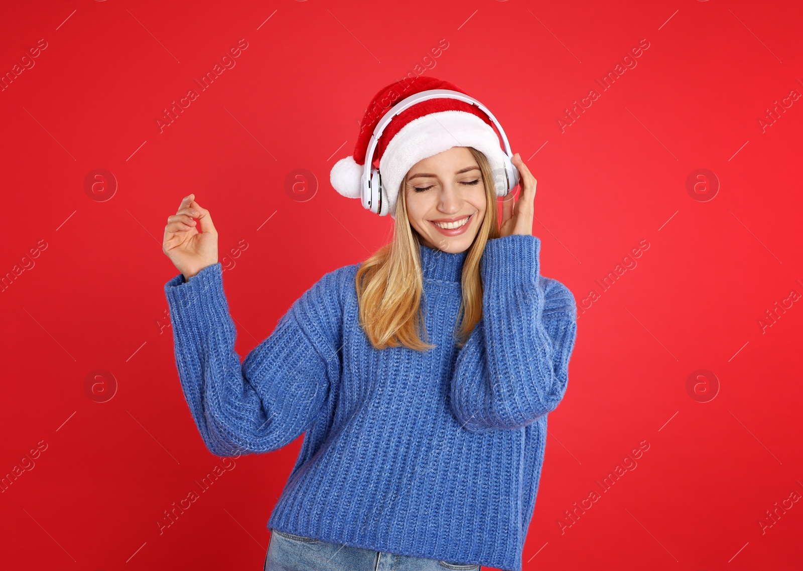 Photo of Happy woman with headphones on red background. Christmas music