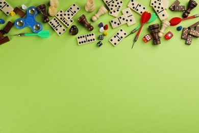 Photo of Components of board games on green background, flat lay. Space for text
