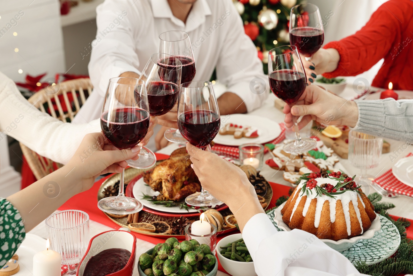 Photo of Family with their friends clinking glasses at festive dinner indoors, closeup. Christmas Eve celebration