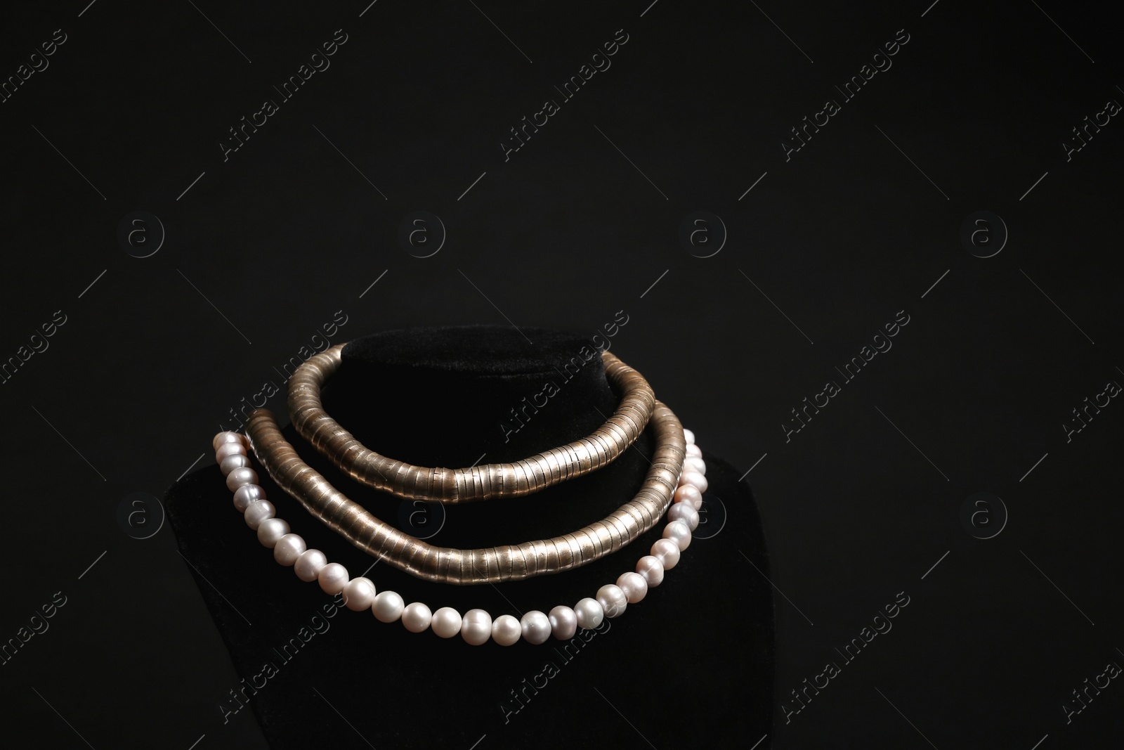 Photo of Stylish necklaces on stand against black background, space for text. Luxury jewelry