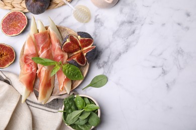 Photo of Tasty melon, jamon and figs served on white marble table, flat lay. Space for text