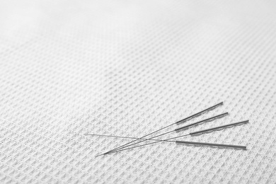 Photo of Acupuncture needles on towel, closeup. Alternative medicine