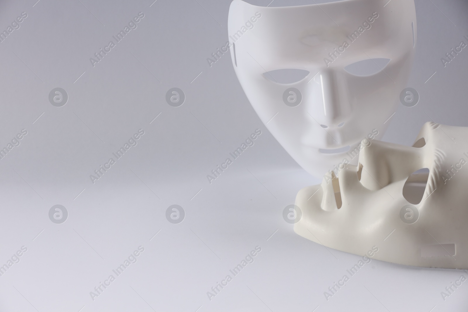 Photo of Plastic face masks on white background, space for text. Theatrical performance